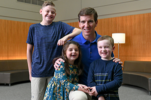 Eli kneeling with kids in room